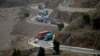 Trucks carry goods on the way to neighboring Afghanistan through the Khyber Pass in Pakistani tribal area, March 21, 2017. A Pakistani border official says hundreds of trucks have crossed into Afghanistan from Pakistan after the border reopened for the fi